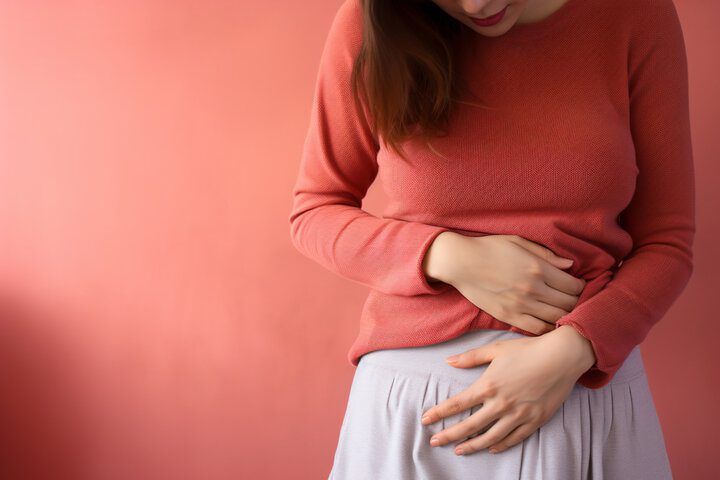 woman holding abdominal area in pain 